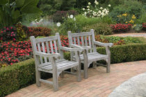 Empty wooden chairs along a garden path von Danita Delimont