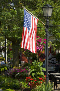 American flag attached to lamp post near wine shop by Danita Delimont