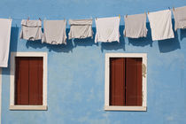 Hanging laundry and windows along blue wall von Danita Delimont