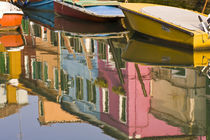 Boats on a canal with reflections of colorful houses on the water by Danita Delimont