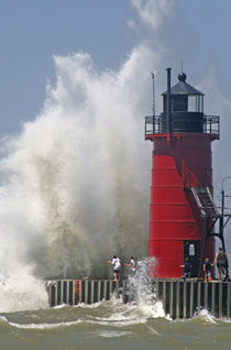 People on jetty watch large breaking waves in South Haven Michigan von Danita Delimont