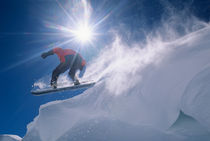 Man jumping off a large cornince on a snowboard on Flagstaff Peak in the Wasatch Mountains of northern Utah von Danita Delimont