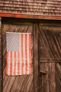 Faded American flag on door of old barn by Danita Delimont