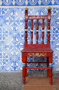 Typical blue tile walls with red chair by Danita Delimont