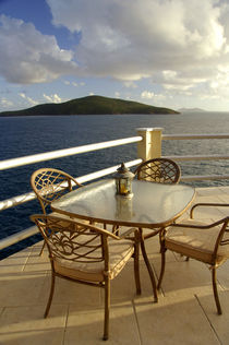 View of the Atlantic and the island of Big Hans Lollik from villa deck with table and chairs by Danita Delimont