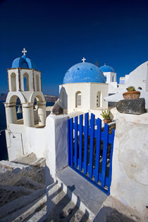 Greece and Greek Island of Santorini town of Oia with Blue Domed Churches with white and colorful buidling surrounding them von Danita Delimont