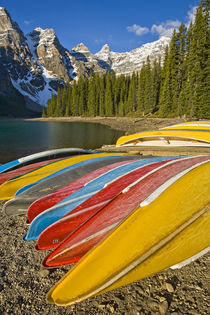Moraine Lake and rental canoes stacked on shore by Danita Delimont