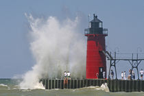 People on jetty watch large breaking waves in South Haven Michigan by Danita Delimont
