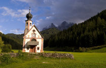 Beautiful isolated lonely church called Rainui in valley in the Italian Dolomites village of Val Di Funes mountains Alpine area of Italy with Dolomites looming behind by Danita Delimont