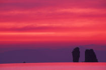 Pink sky reflected in sea with jagged karst (limestone) islands by Danita Delimont