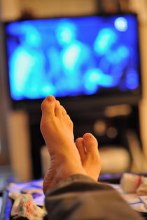 Man watching television feet up by Sami Sarkis Photography