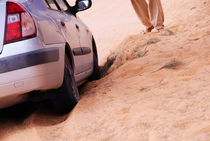 Man standing by car stuck in sand in desert von Sami Sarkis Photography