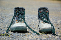Pair of used work boots on road von Sami Sarkis Photography