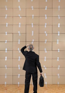Businessman facing a cardboard boxes wall von Sami Sarkis Photography