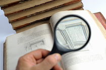 Hand Holding Magnifying Glass on book von Sami Sarkis Photography