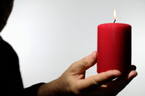 Man holding burning candle by Sami Sarkis Photography