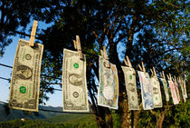 International money hanging on clothesline by Sami Sarkis Photography