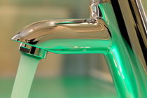 Chrome sink tap with running water by Sami Sarkis Photography