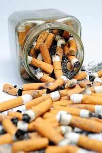 Jar overflowing with cigarette butts by Sami Sarkis Photography