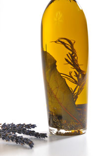 Bottle of herb-infused olive oil and lavender by Sami Sarkis Photography