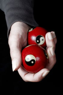 Woman holding Yin Yang balls in hand by Sami Sarkis Photography