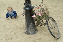 Girl playing with sand near bicycle von Sami Sarkis Photography
