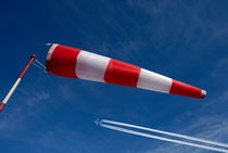 Windsock and airplane against sky by Sami Sarkis Photography