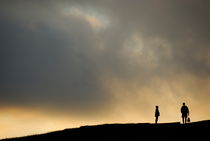 Silhouettes of two people standing on horizon by Sami Sarkis Photography