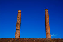 Two chimneys against blue sky by Sami Sarkis Photography