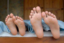 Two children (6-12) lying in bed von Sami Sarkis Photography