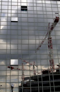 Construction cranes reflected in glass office building von Sami Sarkis Photography