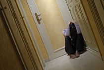 Depressed woman sitting in corridor with head in hands von Sami Sarkis Photography