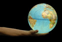 Man offering illuminated Earth globe von Sami Sarkis Photography