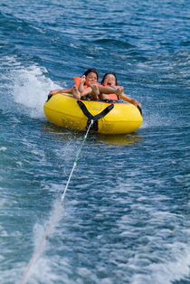 Two children on inflatable ring by Sami Sarkis Photography