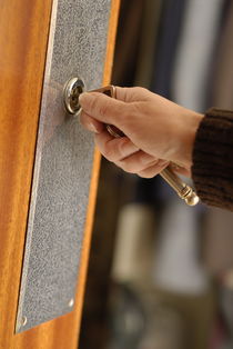 Woman opening front door with key by Sami Sarkis Photography