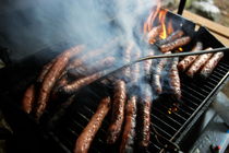 Sausages cooking on barbecue by Sami Sarkis Photography