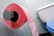 Pink toilet roll on holder in bathroom by Sami Sarkis Photography