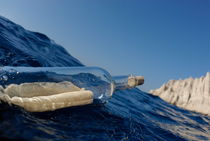 Bottle containing message floating in sea by Sami Sarkis Photography