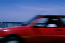 Red car speeding along the Corniche du Président J.F. Kennedy by Sami Sarkis Photography
