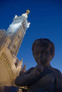 Stone statue of a cherub with view of the bell tower of Notre Dame de la Garde von Sami Sarkis Photography