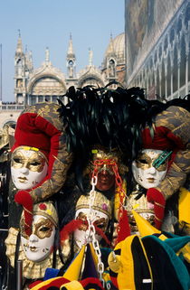 Person surrounded by elaborate masks for sale on St Mark's Basilica von Sami Sarkis Photography