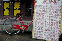 Red bicycle parked behind a long list of menu prices by a restaurant in Datong by Sami Sarkis Photography
