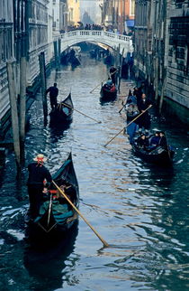 Tourists travelling on gondolas through a narrow canal von Sami Sarkis Photography