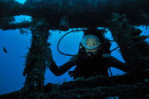 Diver exploring shipwreck by Sami Sarkis Photography