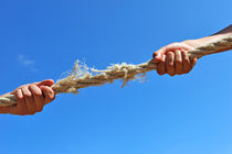 Teenagers hands playing tug-of-war with used rope von Sami Sarkis Photography