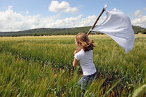 Girl with a white flag in wheat field von Sami Sarkis Photography