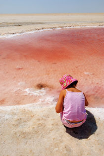 Girl looking at reddish dry salt lake by Sami Sarkis Photography