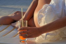 Woman holding cocktail glass while sunbathing by Sami Sarkis Photography