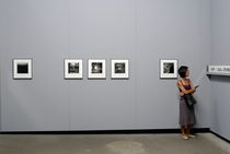 Woman watching photos at exhibition von Sami Sarkis Photography