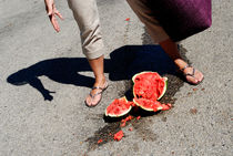 Woman standing by broken watermelon on asphalt von Sami Sarkis Photography